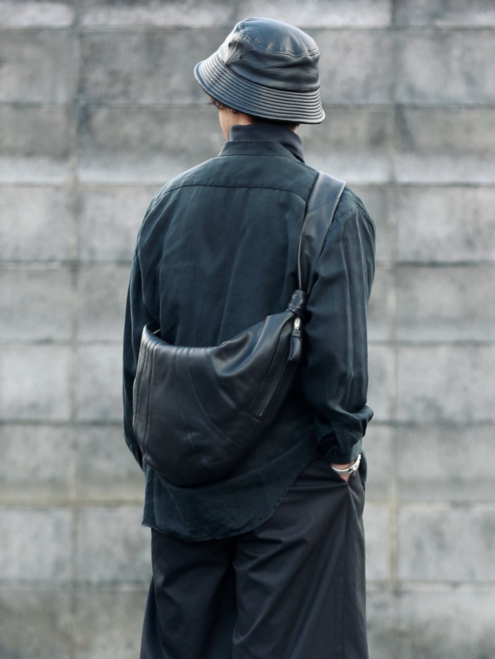 ブラック系のショルダーバッグ、ブラック系のパンツ、ブラック系のブーツを着用したメンズの秋コーディネートの3枚目の写真