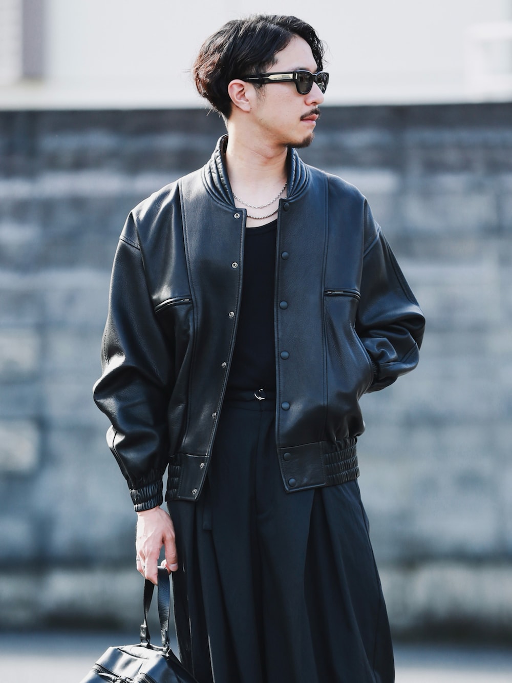 ブラック系のその他アウター、ブラック系のパンツ、ブラック系のショルダーバッグを着用したメンズの秋コーディネートの3枚目の写真