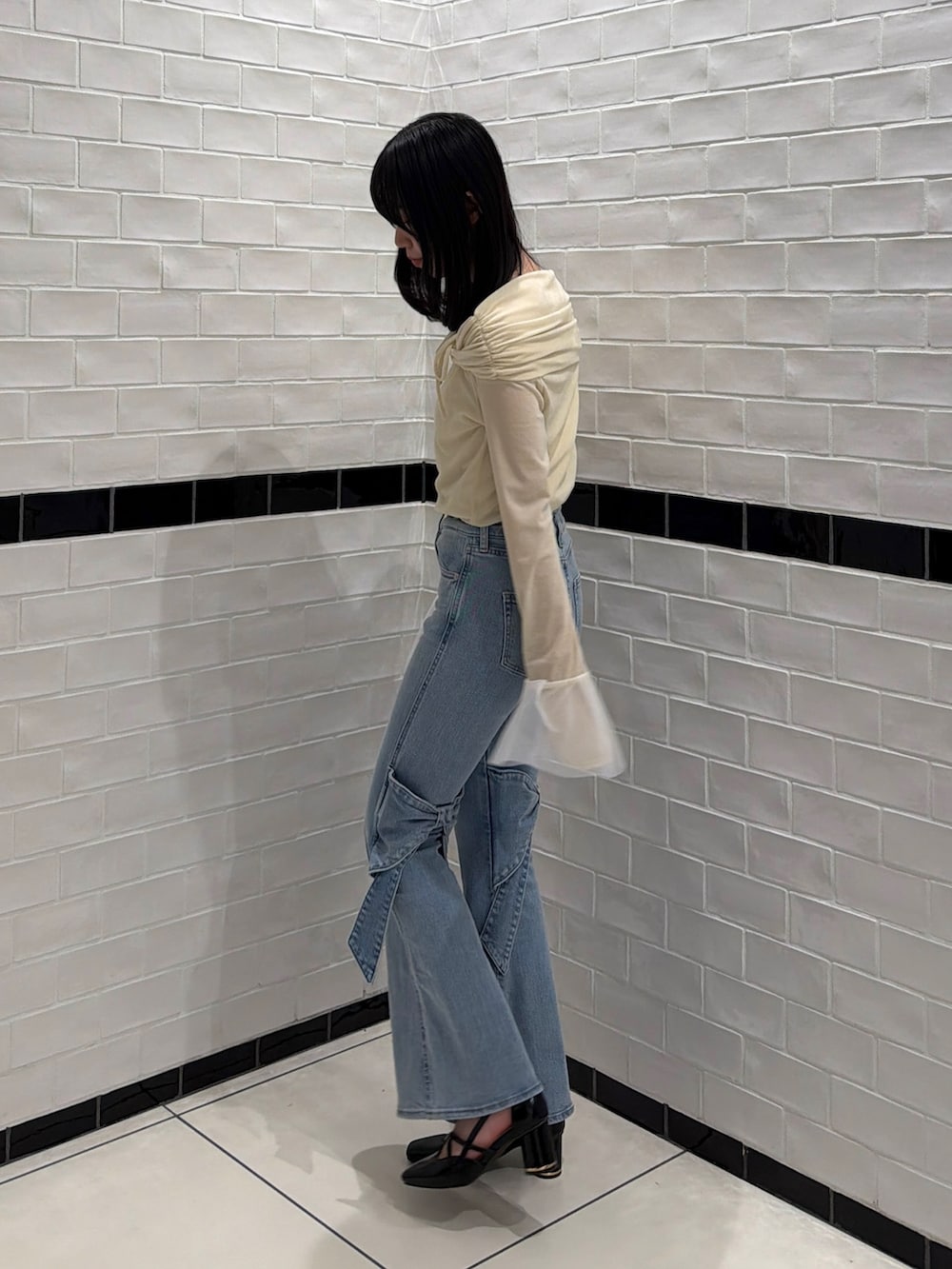 ブルー系のデニムパンツ、ホワイト系のTシャツ/カットソー、ブラック系のサンダルを着用したレディースの冬コーディネートの3枚目の写真