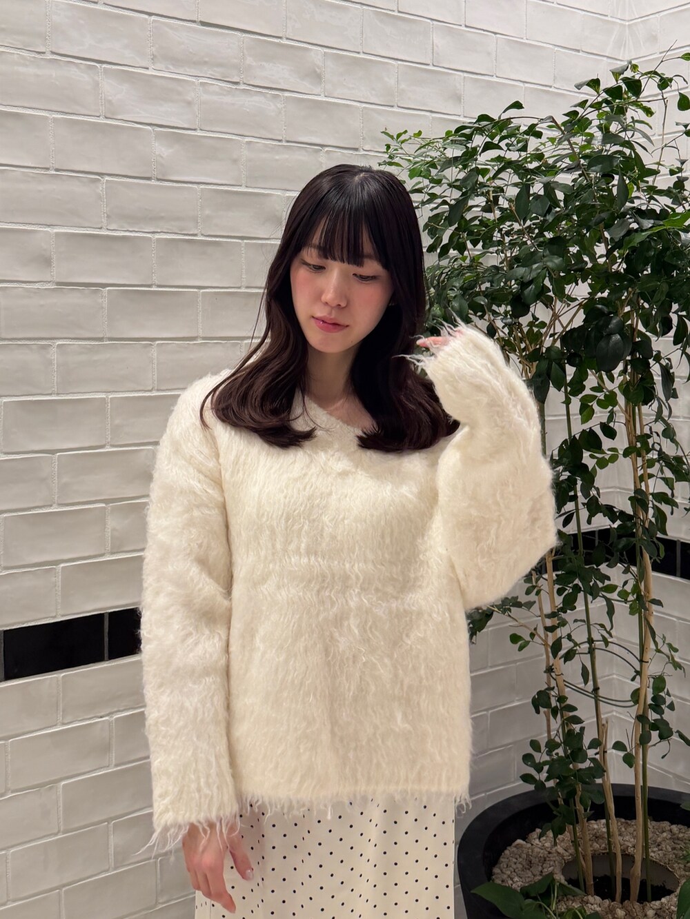 ホワイト系のニット/セーター、ホワイト系のスカート、ホワイト系のローファーを着用したレディースの秋コーディネートの5枚目の写真