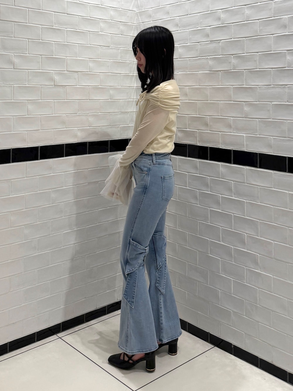 ブルー系のデニムパンツ、ホワイト系のTシャツ/カットソー、ブラック系のサンダルを着用したレディースの冬コーディネートの4枚目の写真