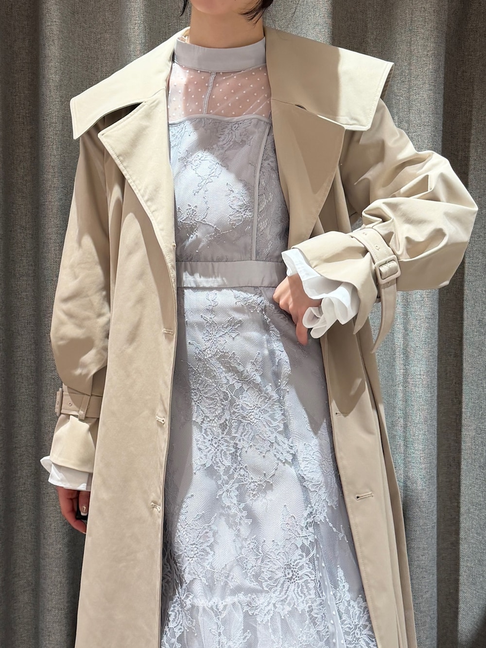 ベージュ系のトレンチコート、ブルー系のドレス、ホワイト系のサンダルを着用したレディースの春コーディネートの7枚目の写真