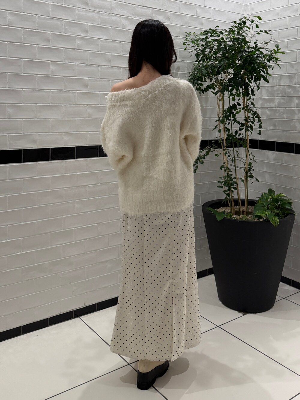 ホワイト系のニット/セーター、ホワイト系のスカート、ホワイト系のローファーを着用したレディースの秋コーディネートの4枚目の写真