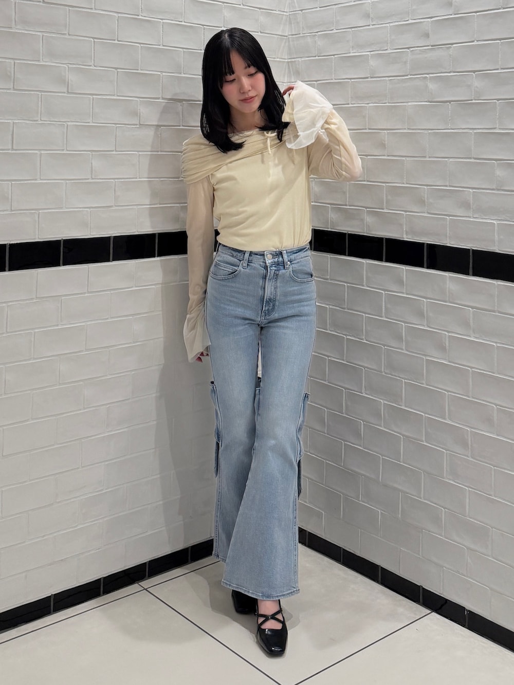 ブルー系のデニムパンツ、ホワイト系のTシャツ/カットソー、ブラック系のサンダルを着用したレディースの冬コーディネートの2枚目の写真