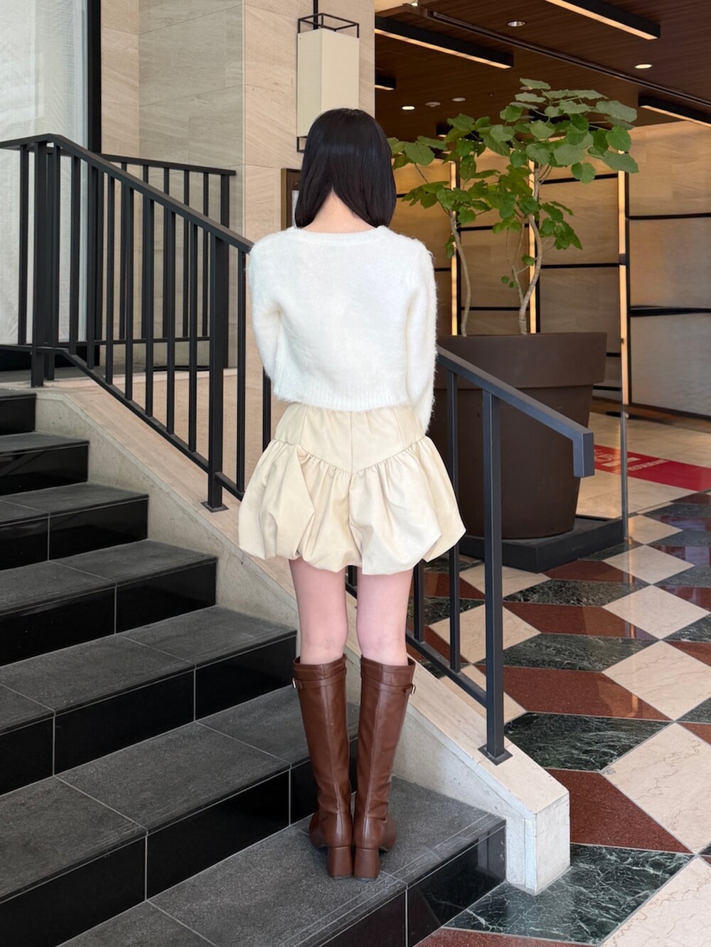 ホワイト系のカーディガン/ボレロ、ホワイト系のその他パンツ、ブラウン系のブーツを着用したレディースの冬コーディネートの4枚目の写真