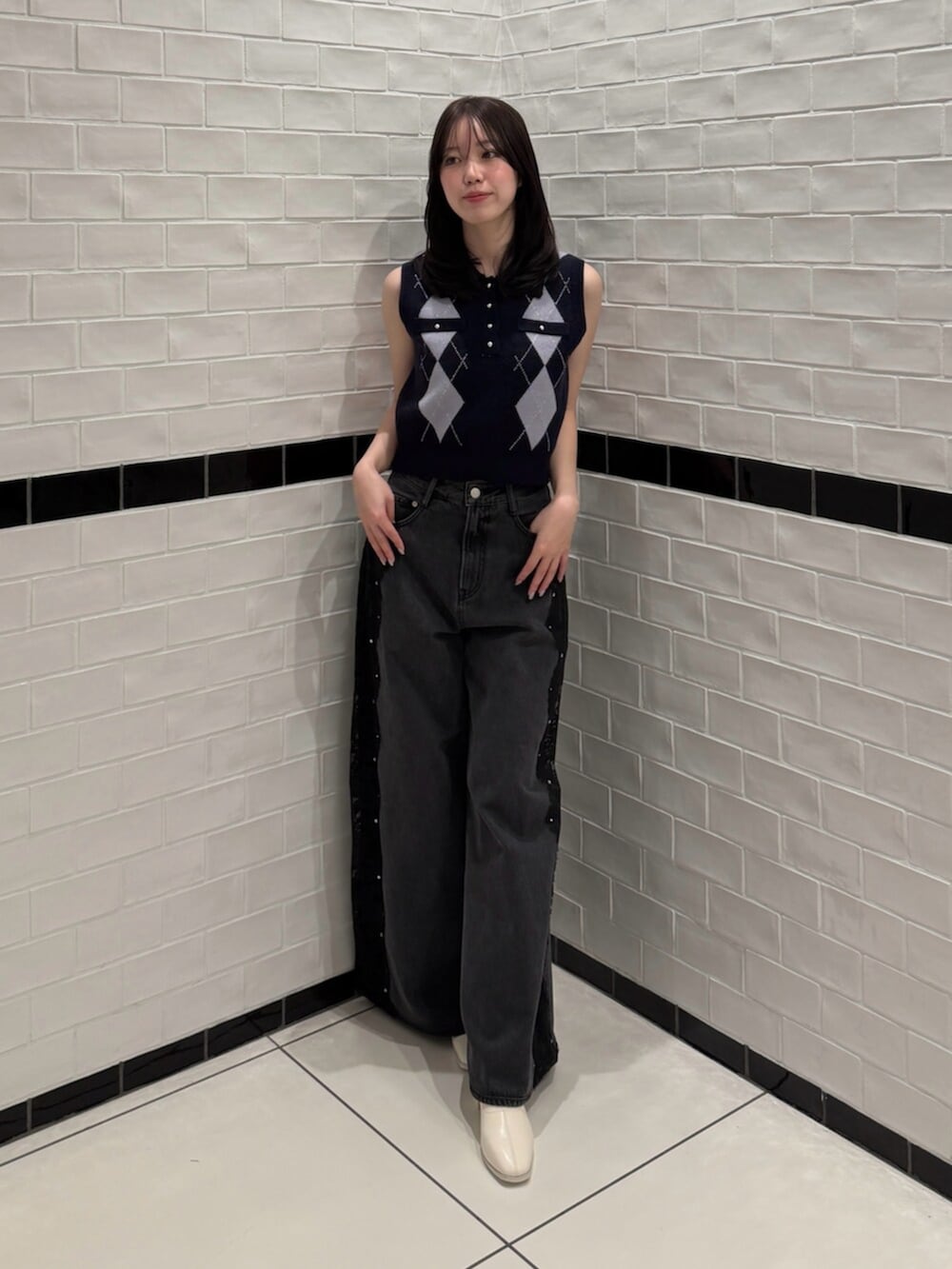 ブルー系のニット/セーター、ブラック系のデニムパンツ、ホワイト系のブーツを着用したレディースの夏コーディネートの4枚目の写真