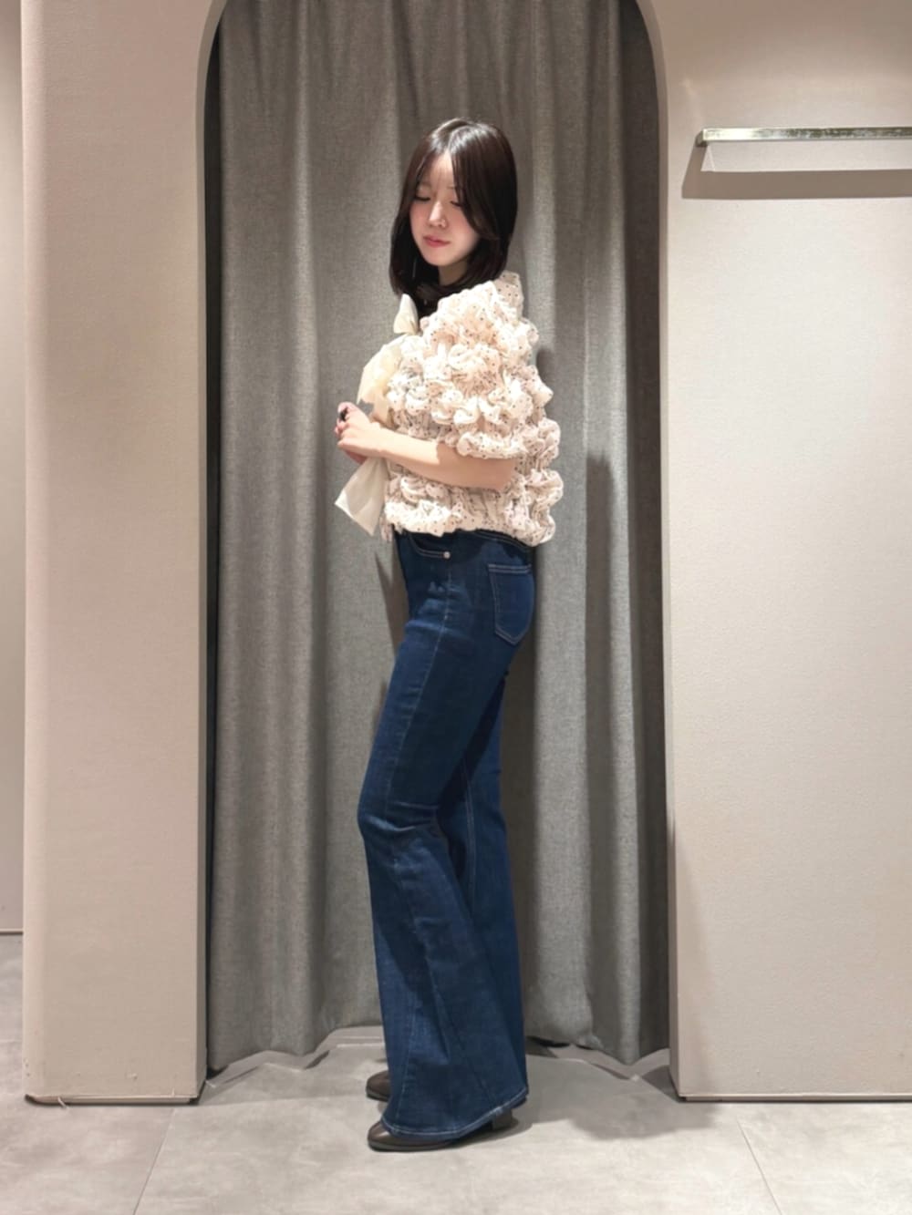 ブラウン系のブーツ、ホワイト系のシャツ/ブラウス、ブルー系のデニムパンツを着用したレディースの秋コーディネートの2枚目の写真