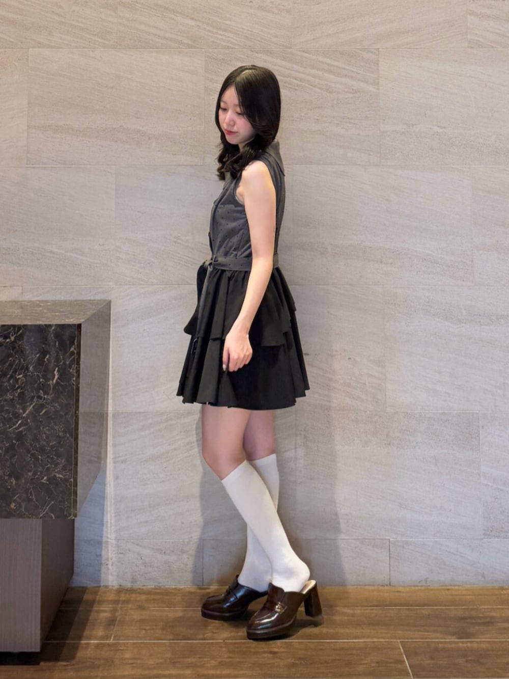 ブラウン系のパンプス、ブラック系のワンピースを着用したレディースの夏コーディネートの2枚目の写真