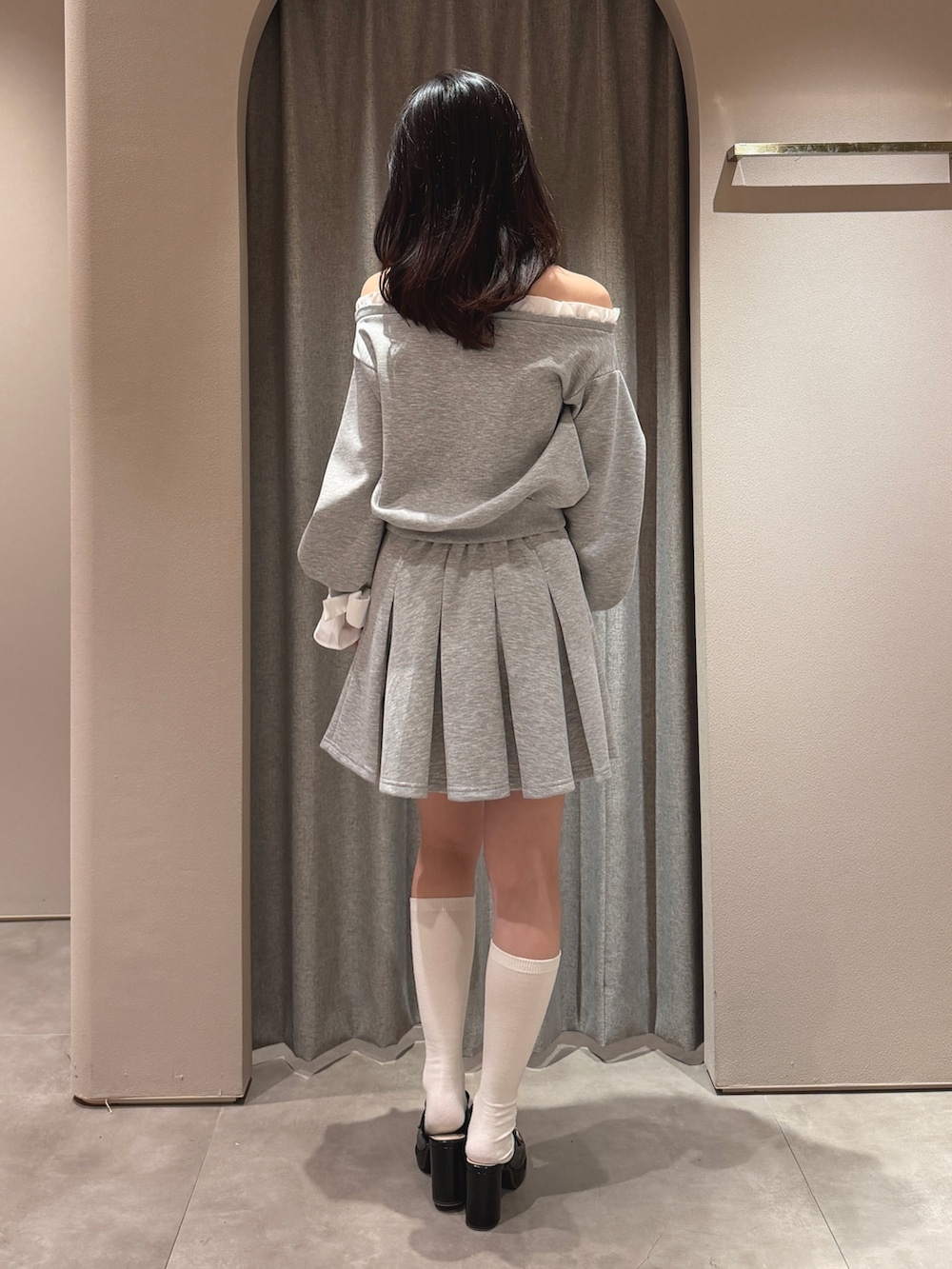 グレー系のTシャツ/カットソー、グレー系のスカート、ブラック系のパンプスを着用したレディースの春コーディネートの4枚目の写真