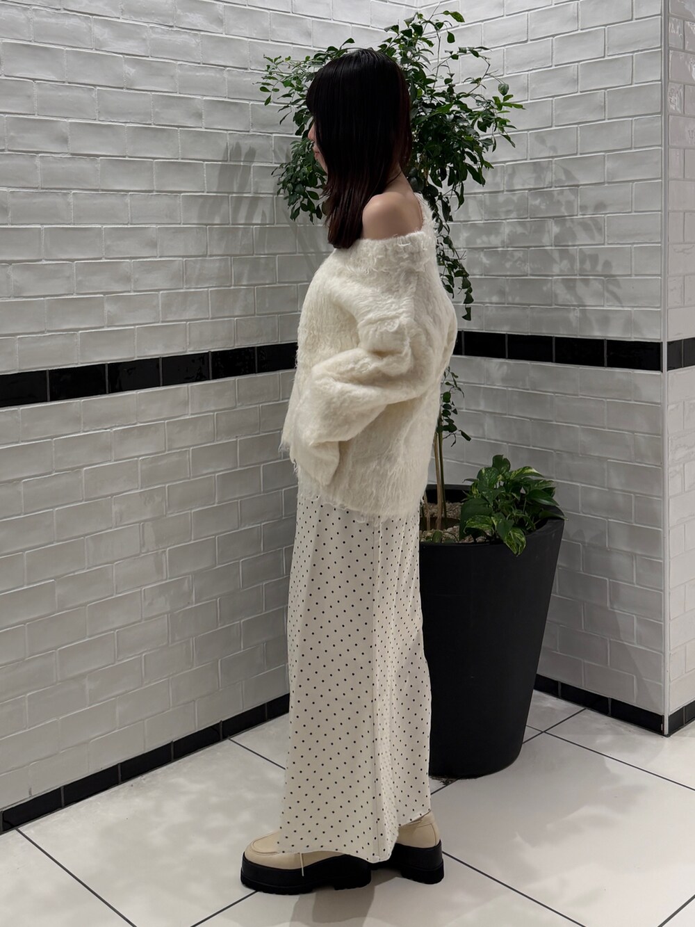 ホワイト系のニット/セーター、ホワイト系のスカート、ホワイト系のローファーを着用したレディースの秋コーディネートの3枚目の写真