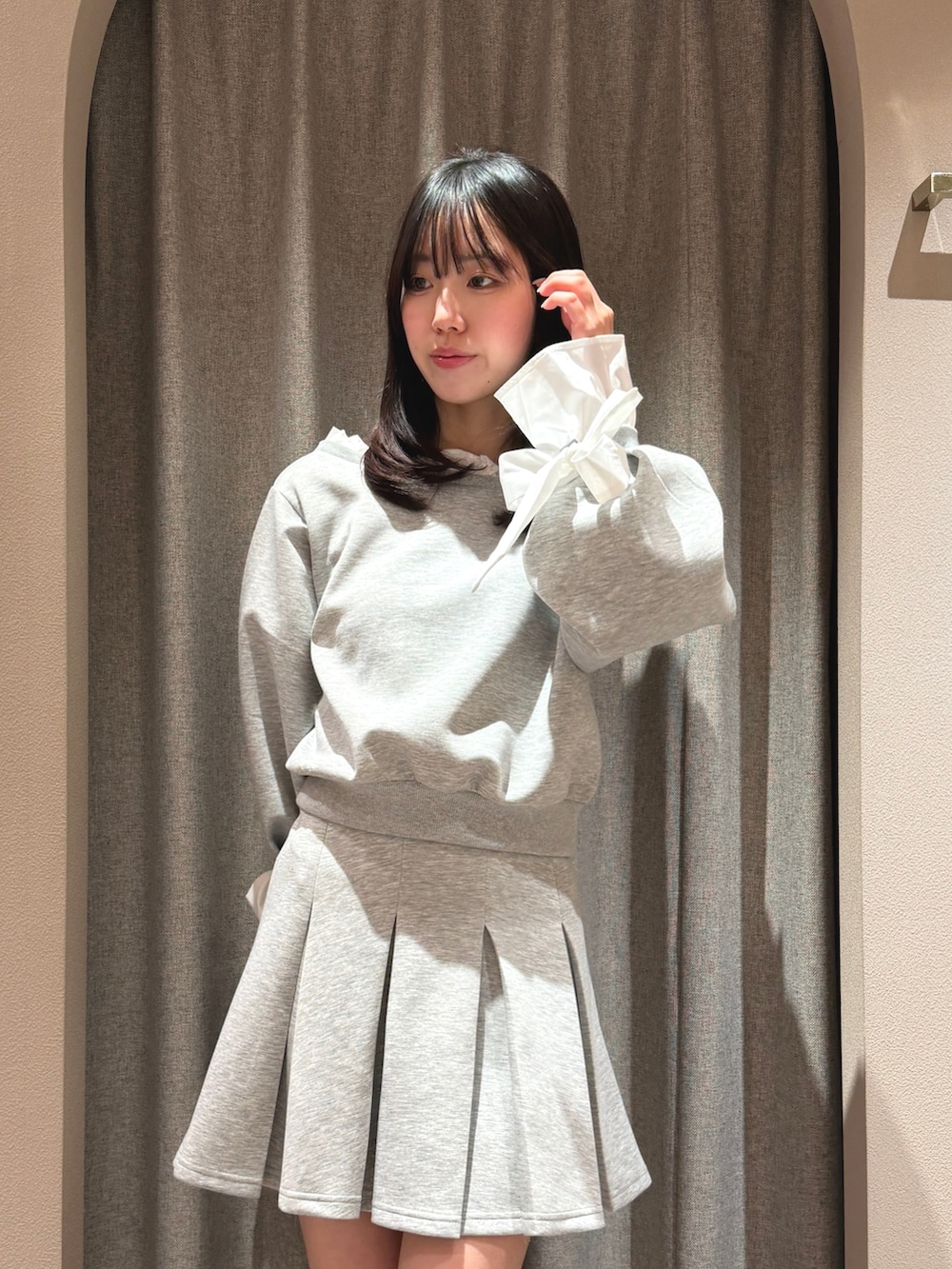 グレー系のTシャツ/カットソー、グレー系のスカート、ブラック系のパンプスを着用したレディースの春コーディネートの6枚目の写真