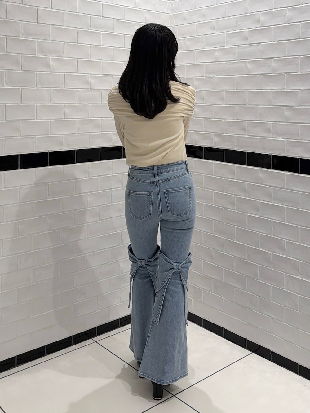 ブルー系のデニムパンツ、ホワイト系のTシャツ/カットソー、ブラック系のサンダルを着用したレディースの冬コーディネートの5枚目の写真