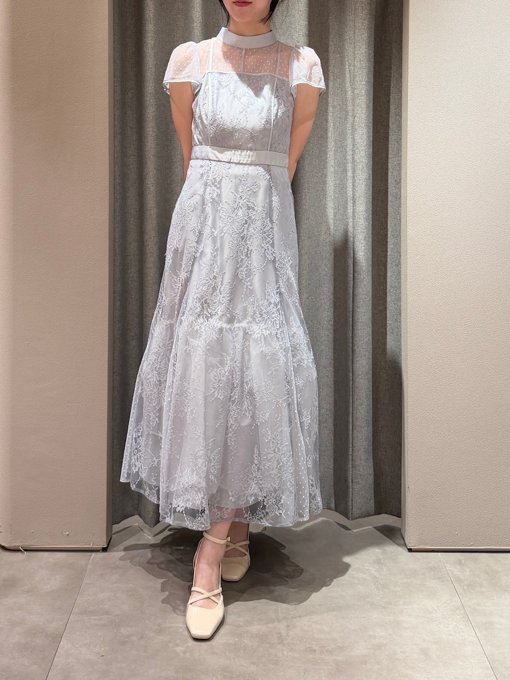 ベージュ系のトレンチコート、ブルー系のドレス、ホワイト系のサンダルを着用したレディースの春コーディネートの5枚目の写真