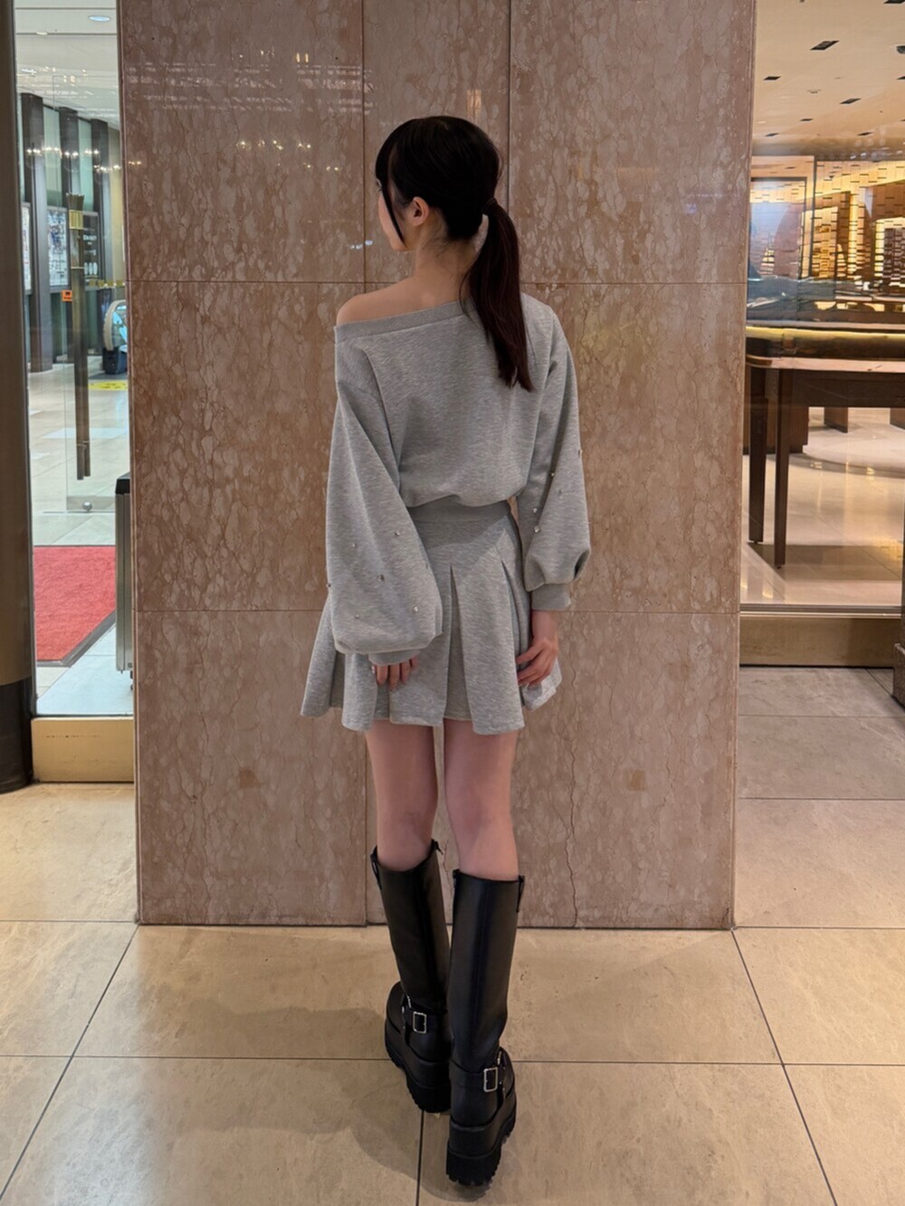 グレー系のテーラードジャケット、グレー系のスウェット、グレー系のスカートを着用したレディースの秋コーディネートの5枚目の写真