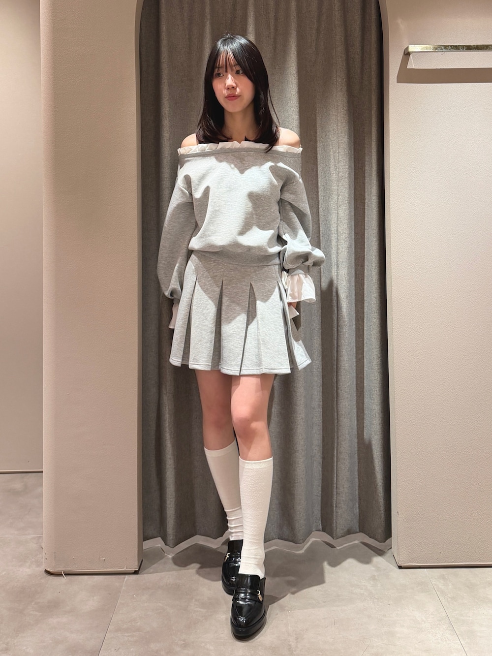 グレー系のTシャツ/カットソー、グレー系のスカート、ブラック系のパンプスを着用したレディースの春コーディネートの2枚目の写真