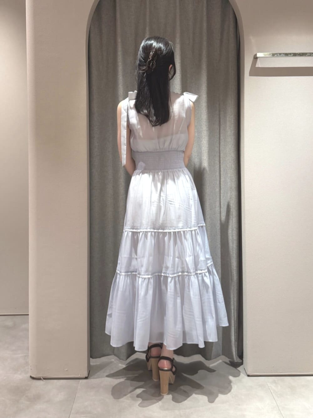 ブラウン系のサンダル、ブルー系のワンピース、ブラウン系のかごバッグを着用したレディースの夏コーディネートの5枚目の写真