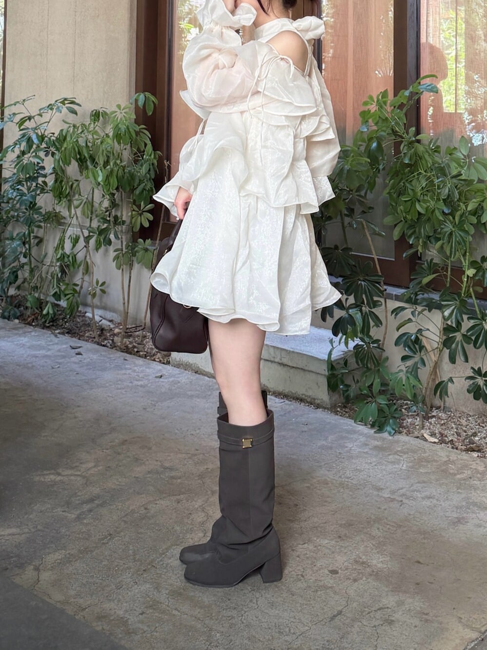 ホワイト系のワンピース、ブラウン系のブーツを着用したレディースの秋コーディネートの2枚目の写真
