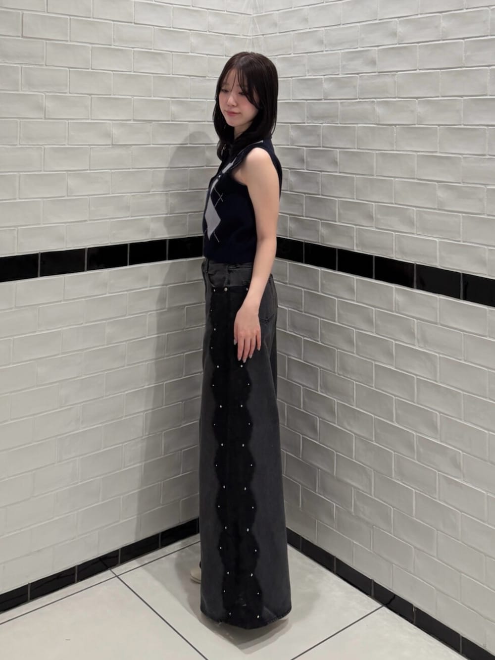 ブルー系のニット/セーター、ブラック系のデニムパンツ、ホワイト系のブーツを着用したレディースの夏コーディネートの2枚目の写真