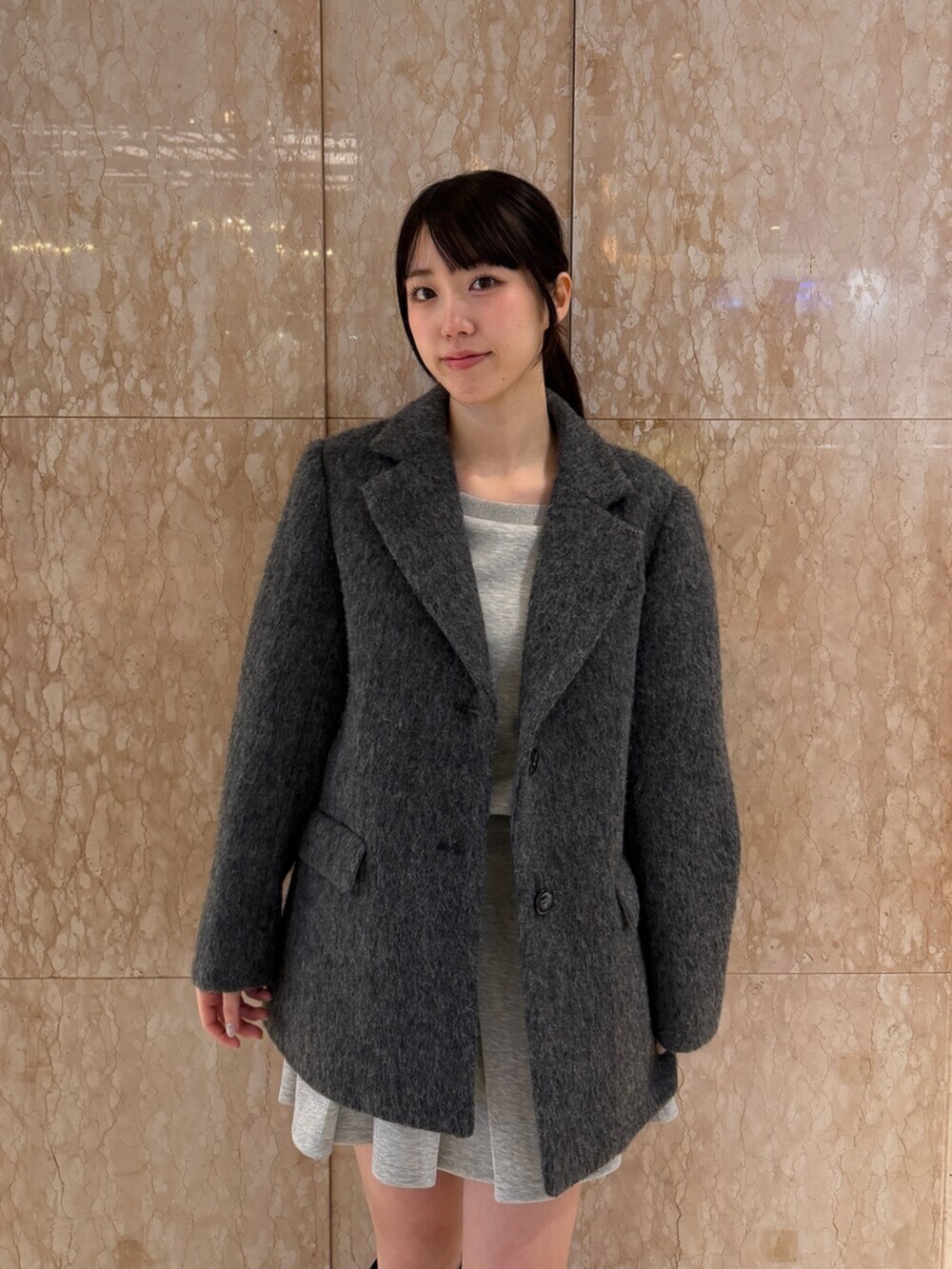 グレー系のテーラードジャケット、グレー系のスウェット、グレー系のスカートを着用したレディースの秋コーディネートの6枚目の写真