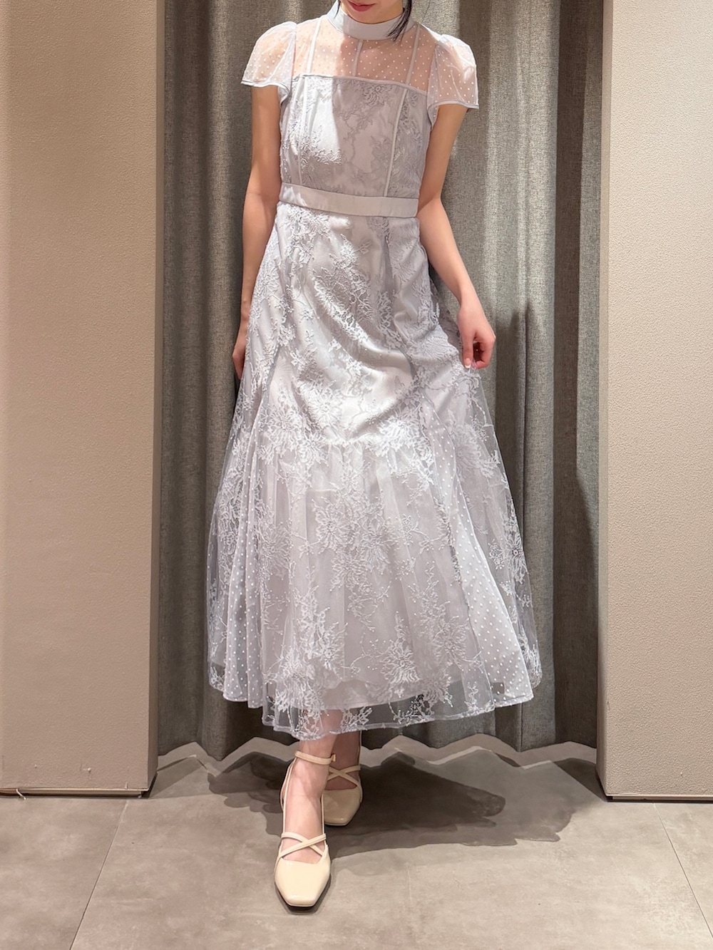 ベージュ系のトレンチコート、ブルー系のドレス、ホワイト系のサンダルを着用したレディースの春コーディネートの4枚目の写真