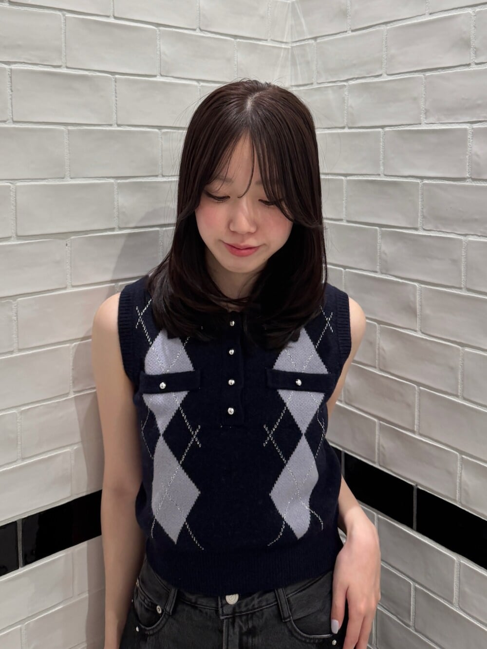ブルー系のニット/セーター、ブラック系のデニムパンツ、ホワイト系のブーツを着用したレディースの夏コーディネートの5枚目の写真