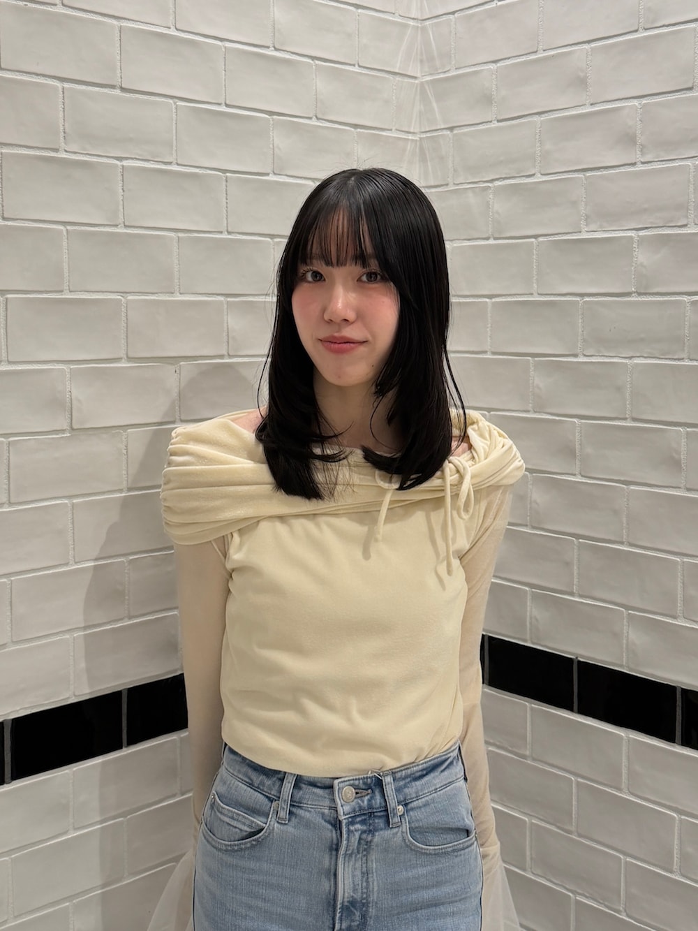 ブルー系のデニムパンツ、ホワイト系のTシャツ/カットソー、ブラック系のサンダルを着用したレディースの冬コーディネートの6枚目の写真