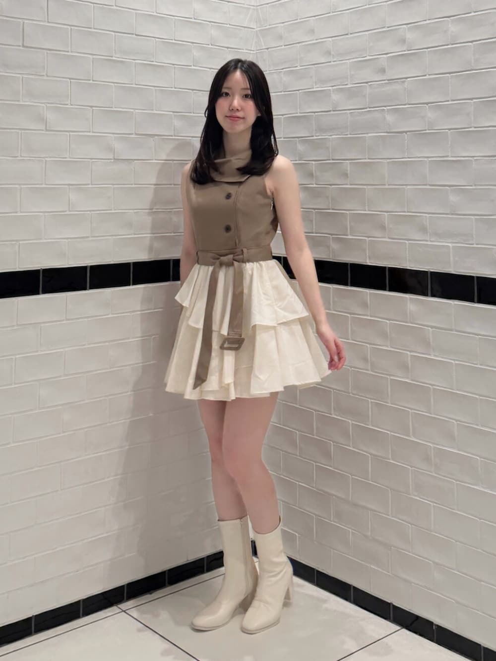 ブラウン系のワンピース、ホワイト系のブーツを着用したレディースの夏コーディネートの2枚目の写真