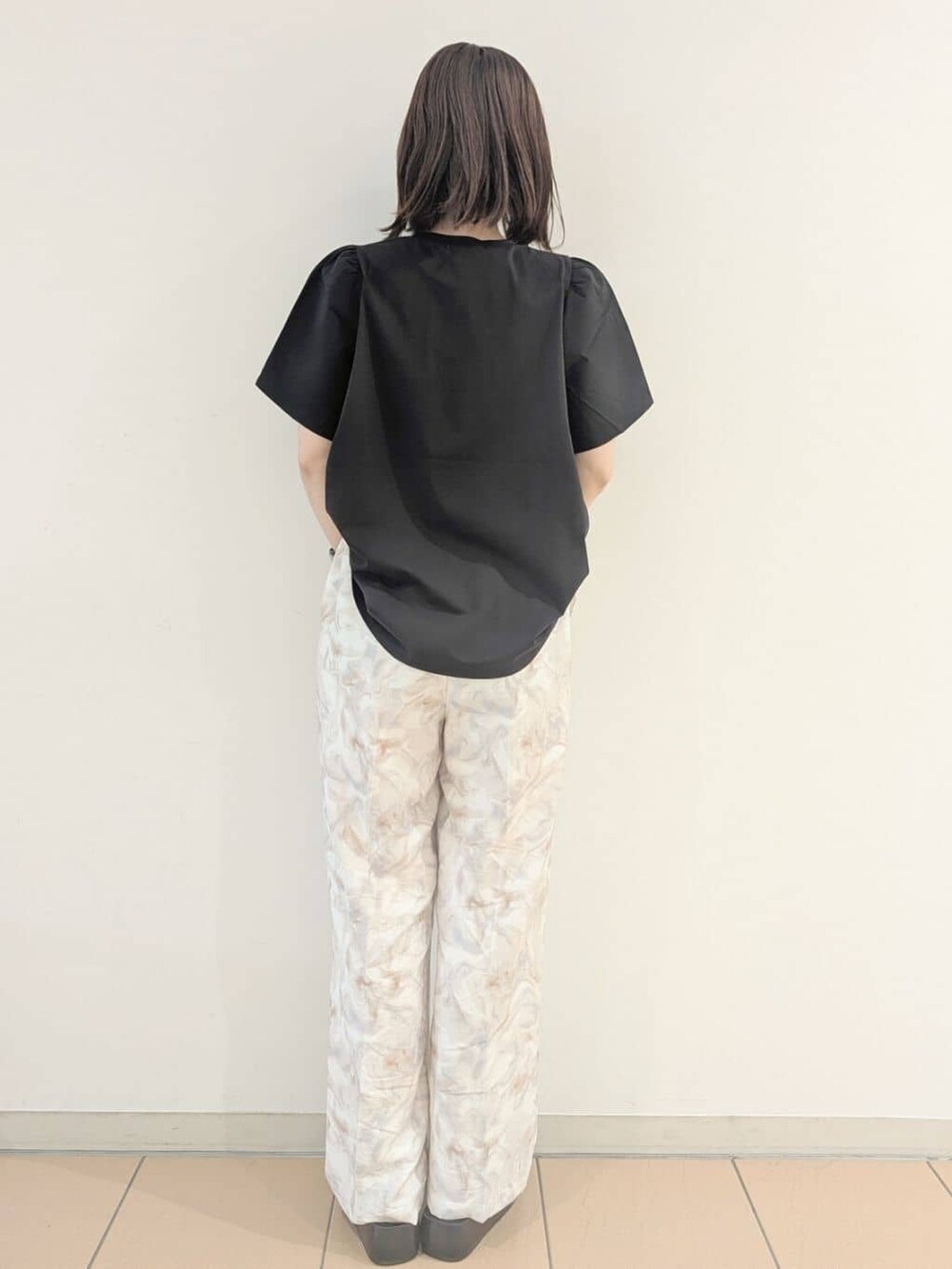 ブラック系のTシャツ/カットソー、グレー系のその他パンツ、ホワイト系のショルダーバッグを着用したレディースの夏コーディネートの4枚目の写真
