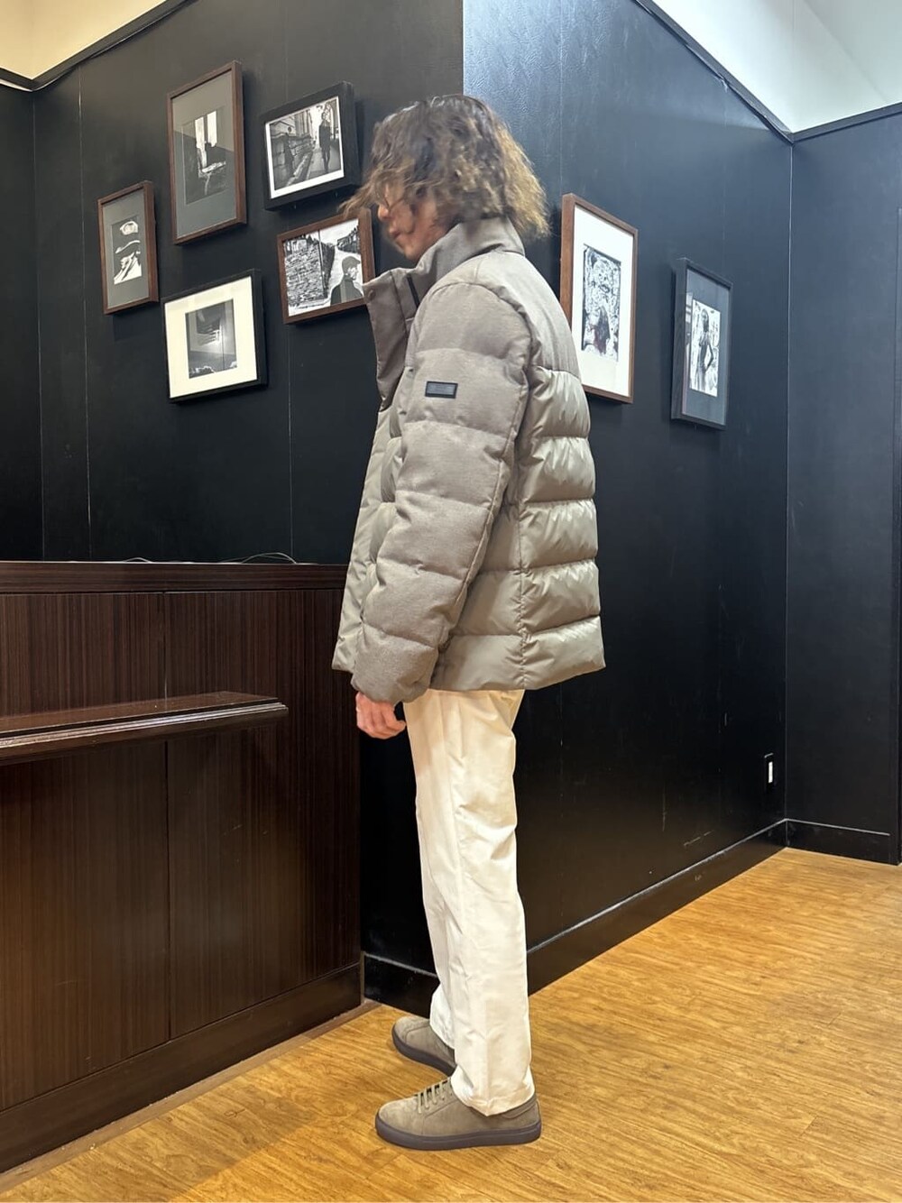 ブラウン系のダウンジャケット/コート、ベージュ系のスラックス、ブラウン系のスニーカーを着用したメンズの冬コーディネートの6枚目の写真