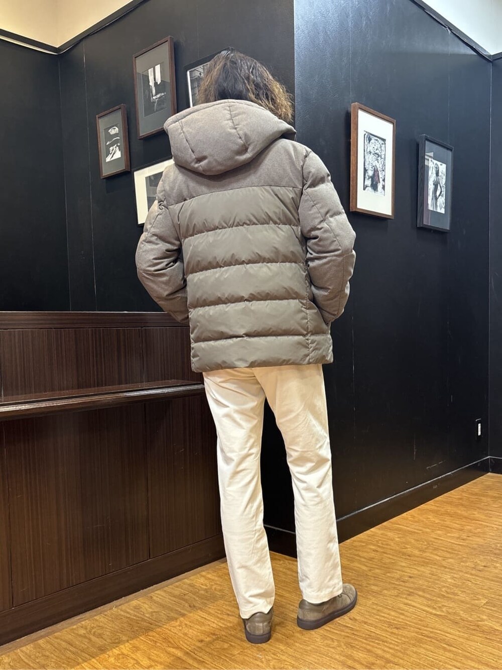 ブラウン系のダウンジャケット/コート、ベージュ系のスラックス、ブラウン系のスニーカーを着用したメンズの冬コーディネートの4枚目の写真