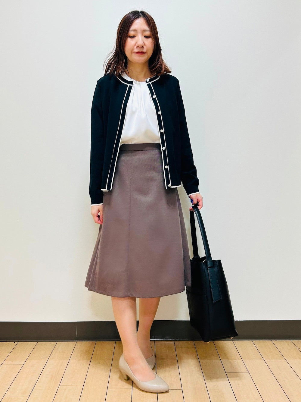 ブラック系のカーディガン/ボレロ、ホワイト系のシャツ/ブラウス、ブラウン系のスカートを着用したレディースの秋コーディネートの2枚目の写真