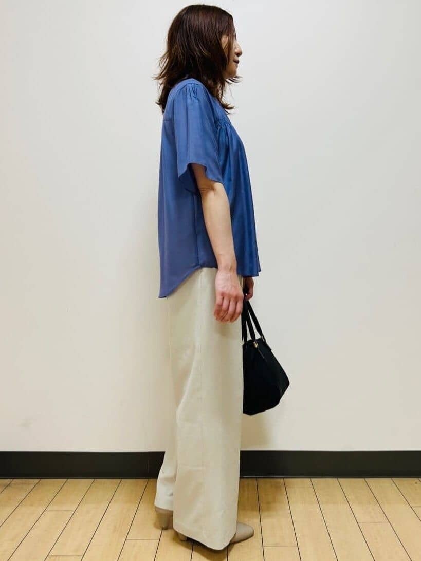 ブルー系のシャツ/ブラウス、ベージュ系のその他パンツ、ブラック系のトートバッグを着用したレディースの夏コーディネートの6枚目の写真