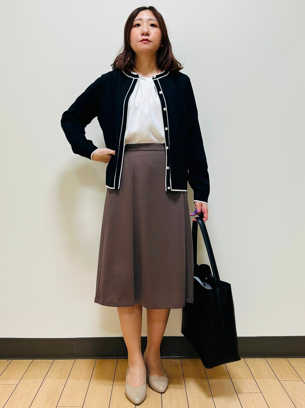 ブラック系のカーディガン/ボレロ、ホワイト系のシャツ/ブラウス、ブラウン系のスカートを着用したレディースの秋コーディネートの7枚目の写真