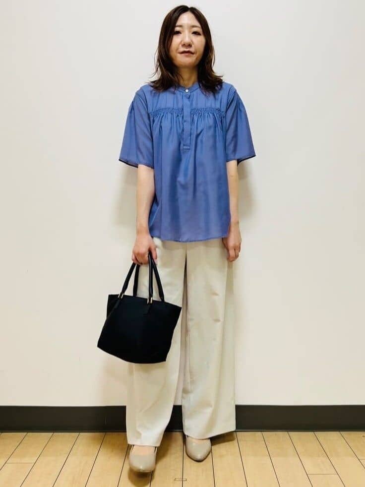 ブルー系のシャツ/ブラウス、ベージュ系のその他パンツ、ブラック系のトートバッグを着用したレディースの夏コーディネートの2枚目の写真