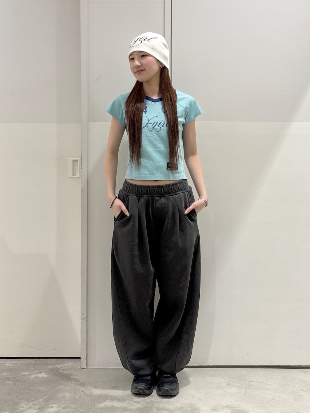 ブラック系のスウェットパンツ、ブラック系のパーカー、グリーン系のTシャツ/カットソーを着用したレディースの春コーディネートの4枚目の写真