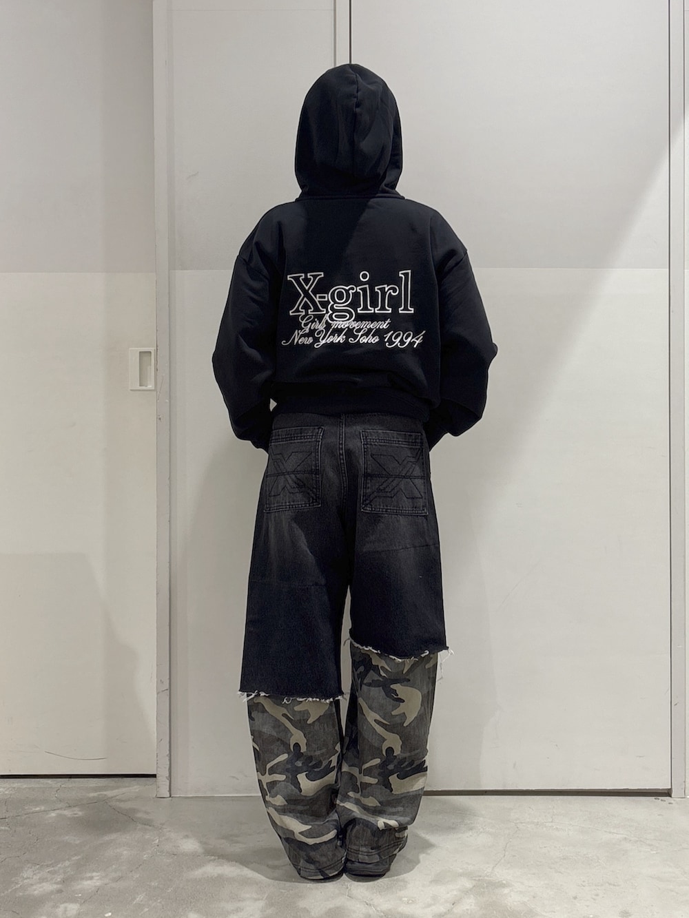 ブラック系のパーカー、ブラック系のトートバッグ、ブラック系のデニムパンツを着用したレディースの春コーディネートの3枚目の写真