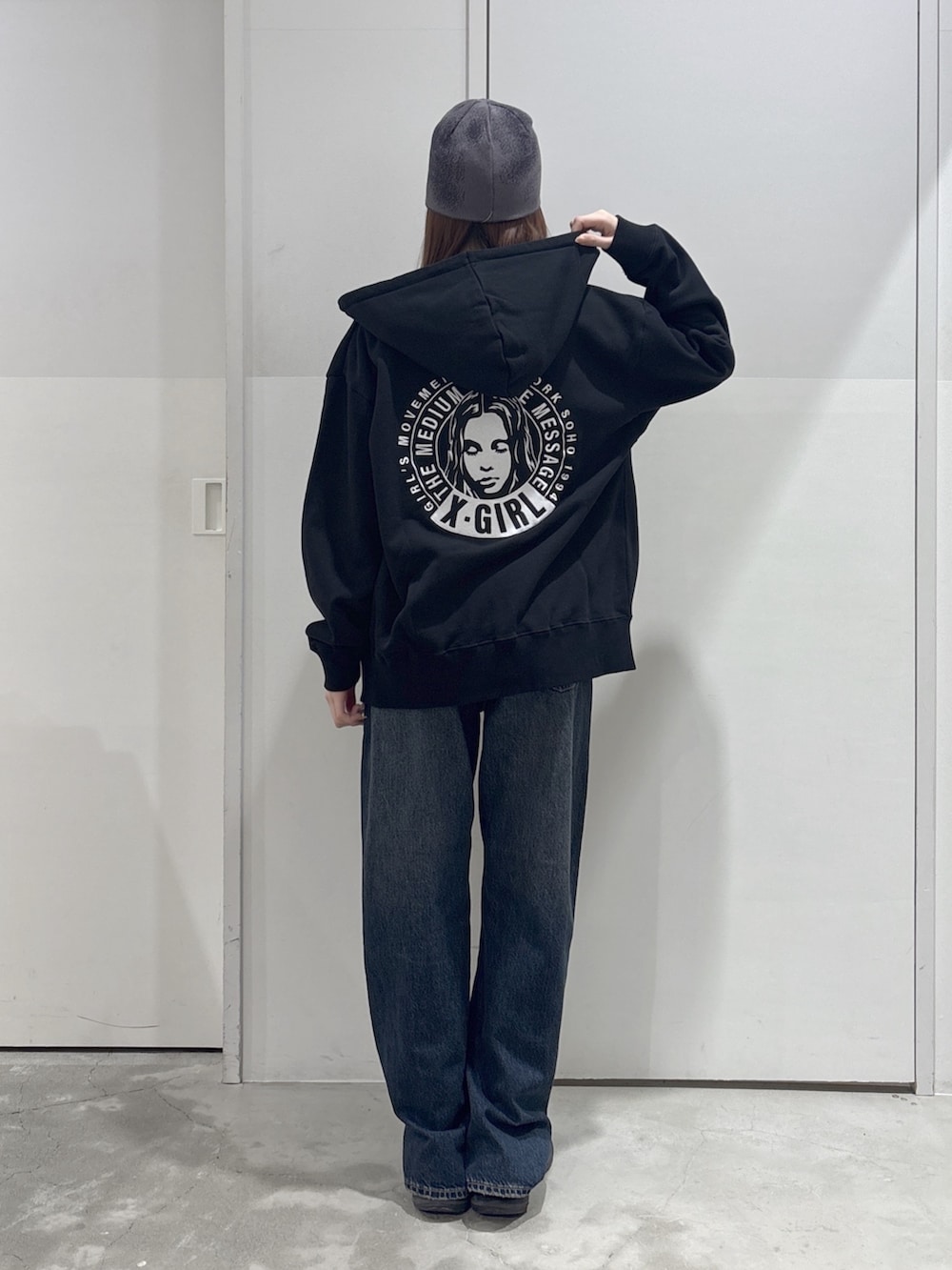 ブラック系のパーカー、ブルー系のデニムパンツ、ブルー系のTシャツ/カットソーを着用したレディースの春コーディネートの2枚目の写真