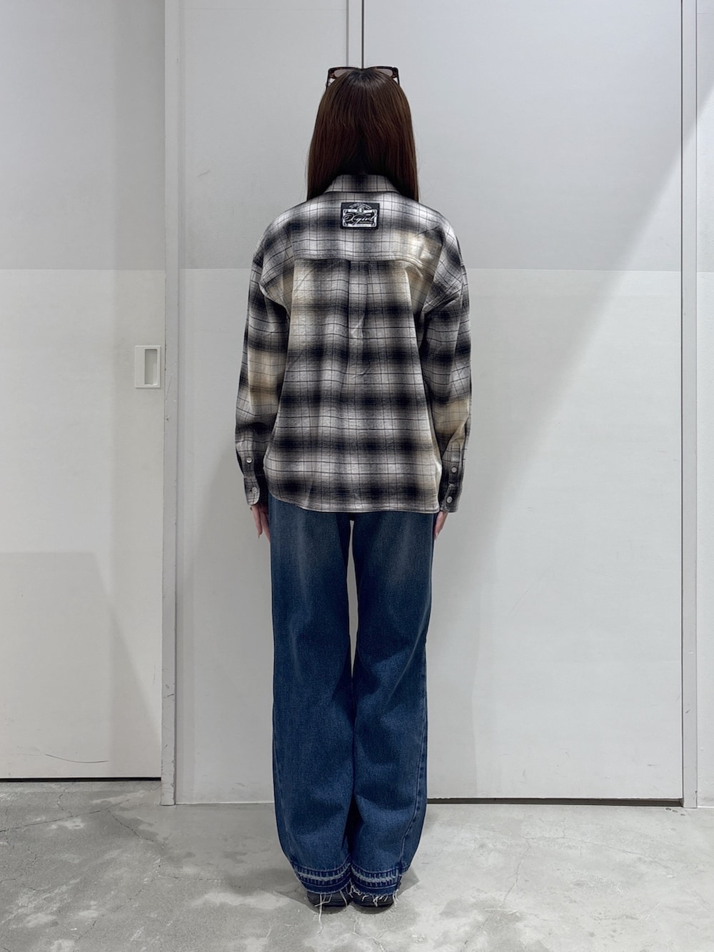 ブラック系のシャツ/ブラウス、レッド系のTシャツ/カットソー、ブルー系のデニムパンツを着用したレディースの春コーディネートの5枚目の写真