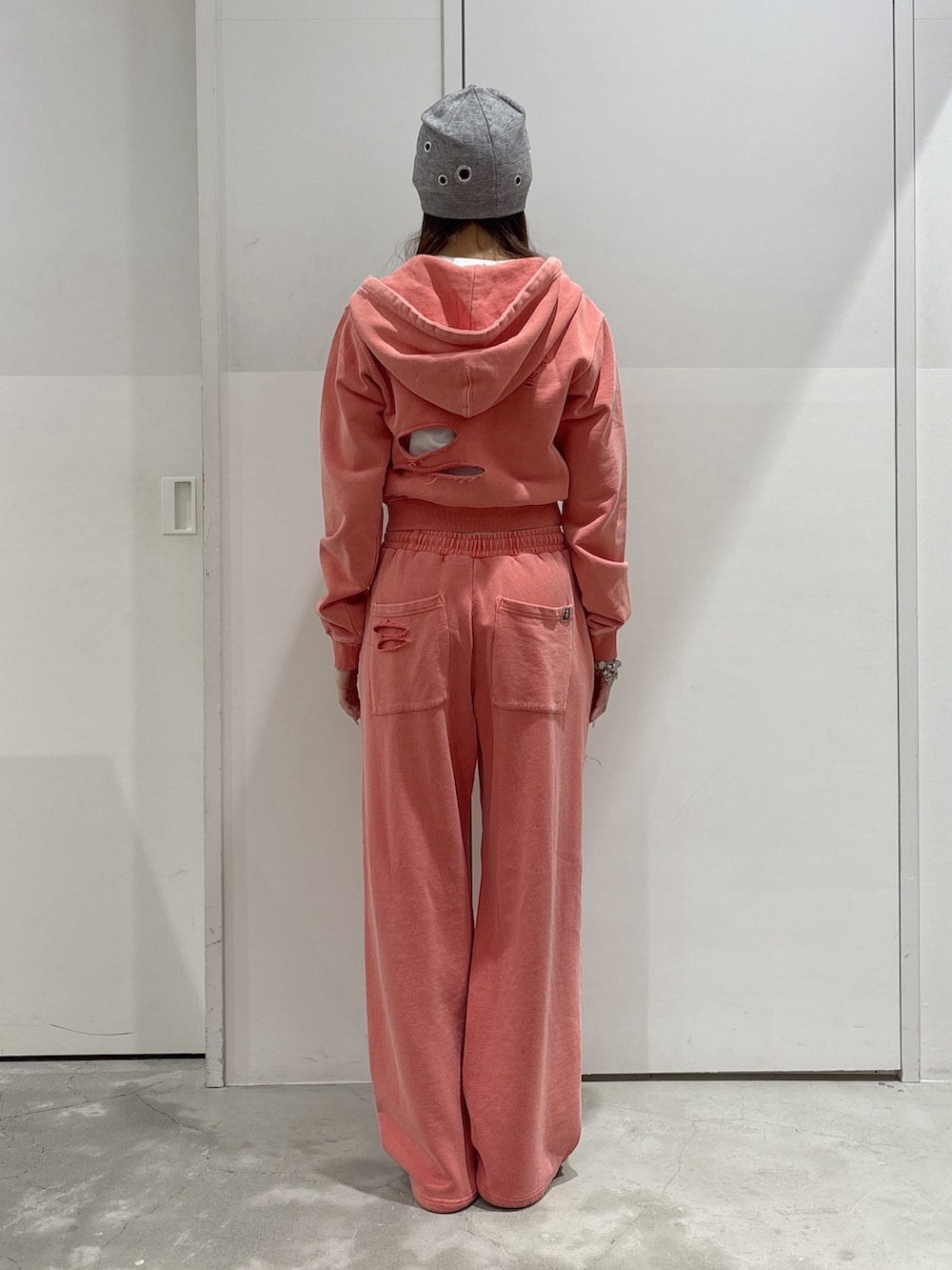 オレンジ系のパーカー、オレンジ系のスウェットパンツ、ブラック系のショルダーバッグを着用したレディースの春コーディネートの3枚目の写真