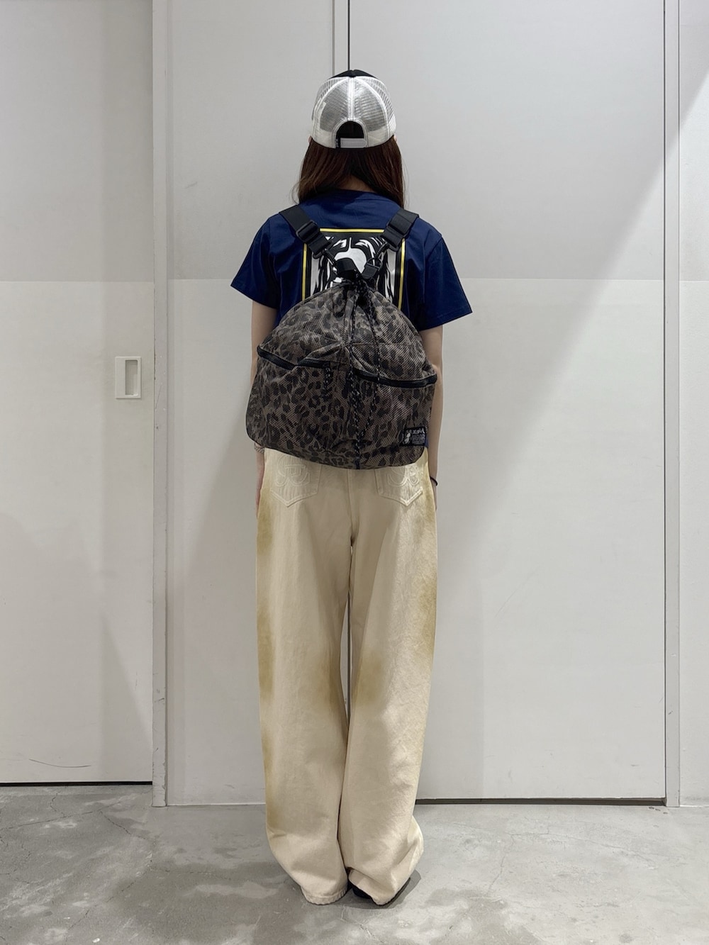 ホワイト系のデニムパンツ、ブルー系のTシャツ/カットソー、ベージュ系のバックパック/リュックを着用したレディースの夏コーディネートの3枚目の写真