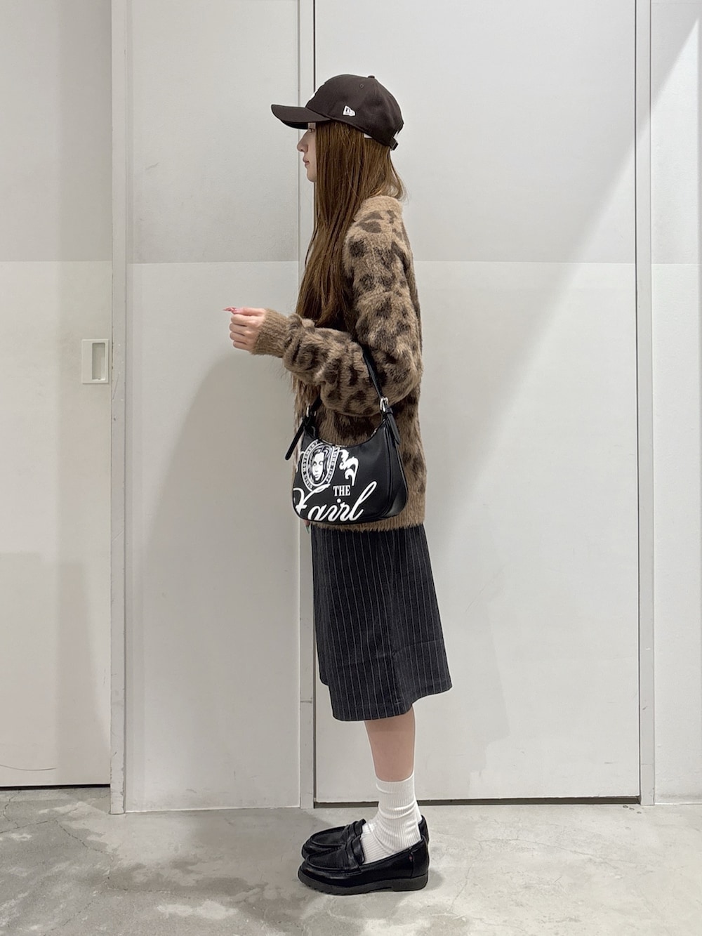 グレー系のその他パンツ、ベージュ系のニット/セーター、ブラック系のハンドバッグを着用したレディースの秋コーディネートの2枚目の写真