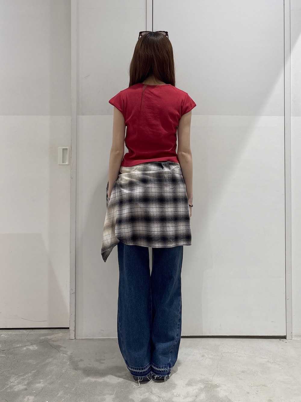 ブラック系のシャツ/ブラウス、レッド系のTシャツ/カットソー、ブルー系のデニムパンツを着用したレディースの春コーディネートの2枚目の写真