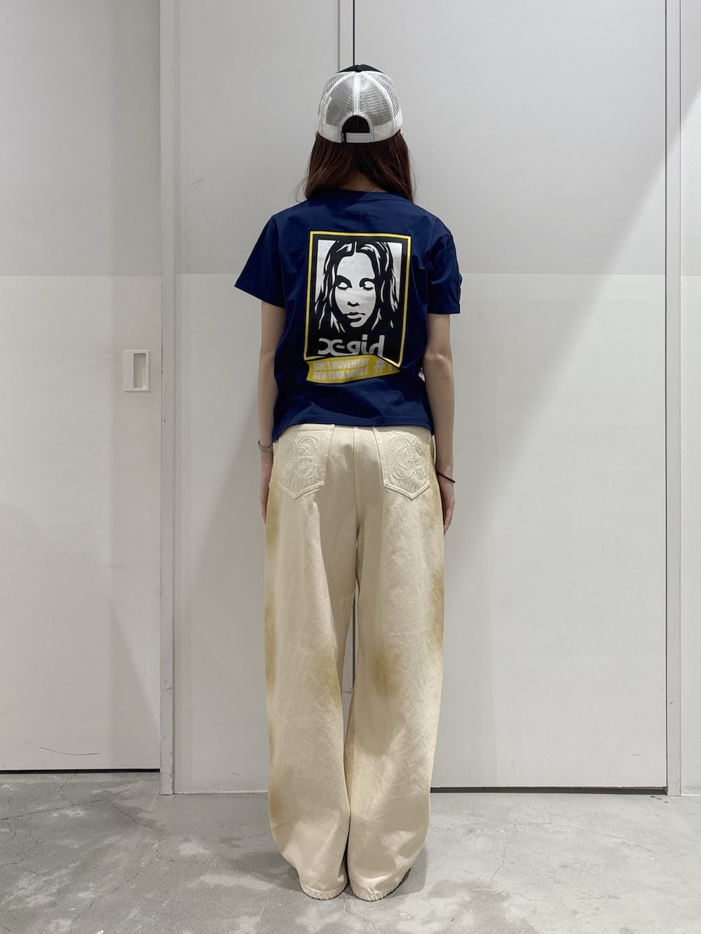 ホワイト系のデニムパンツ、ブルー系のTシャツ/カットソー、ベージュ系のバックパック/リュックを着用したレディースの夏コーディネートの4枚目の写真