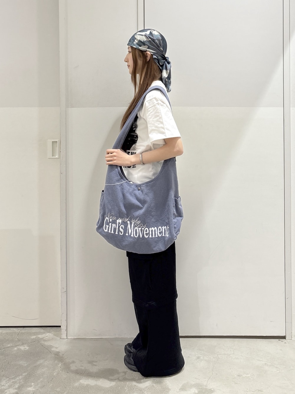 ブラック系のスウェットパンツ、ホワイト系のTシャツ/カットソー、ブルー系のショルダーバッグを着用したレディースの夏コーディネートの2枚目の写真