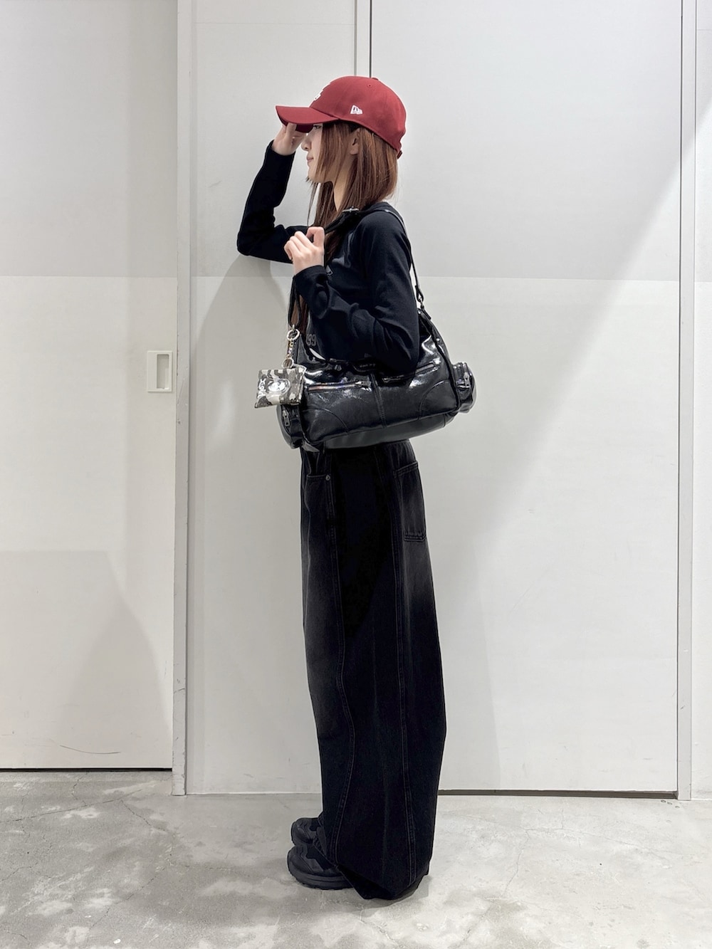 ブラック系のデニムパンツ、グレー系のTシャツ/カットソー、ブラック系のショルダーバッグを着用したレディースの春コーディネートの2枚目の写真