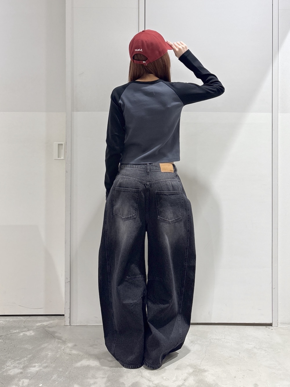 ブラック系のデニムパンツ、グレー系のTシャツ/カットソー、ブラック系のショルダーバッグを着用したレディースの春コーディネートの3枚目の写真