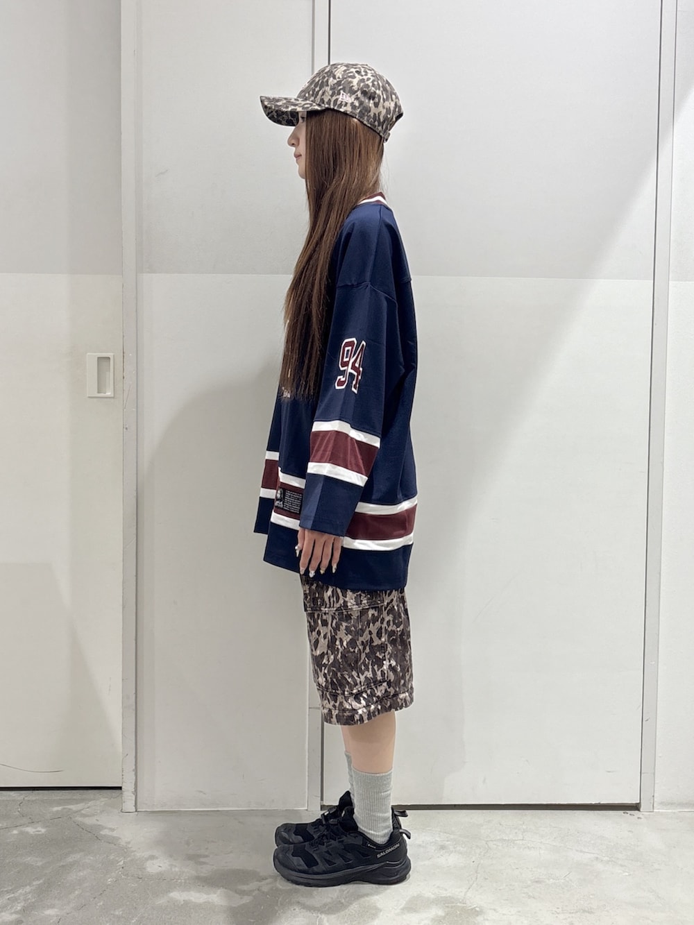ベージュ系のカーゴパンツ、ブルー系のワンピース、ベージュ系のキャップを着用したレディースの夏コーディネートの2枚目の写真