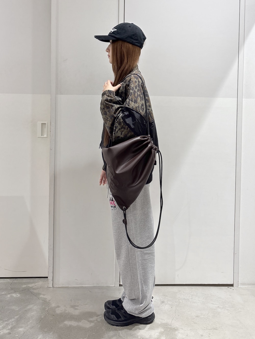 グレー系のスウェットパンツ、ベージュ系のブルゾン、ブラウン系のバックパック/リュックを着用したレディースの夏コーディネートの2枚目の写真