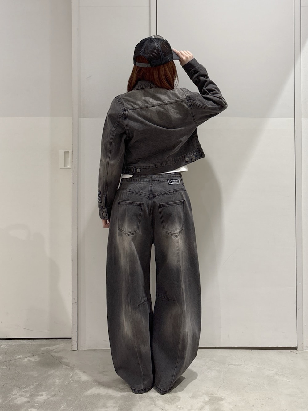 ブラック系のデニムパンツ、ブラック系のデニムジャケット、ホワイト系のTシャツ/カットソーを着用したレディースの春コーディネートの3枚目の写真