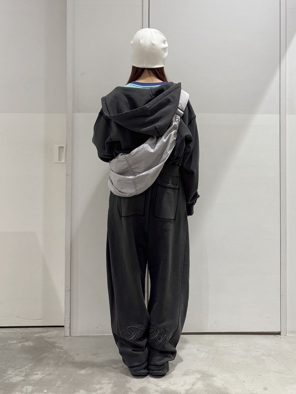 ブラック系のスウェットパンツ、ブラック系のパーカー、グリーン系のTシャツ/カットソーを着用したレディースの春コーディネートの3枚目の写真